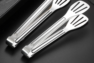 Détail de deux pinces alimentaires en acier inoxydable avec design ajouré pour drainage