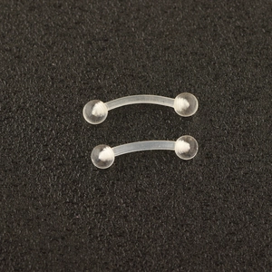 Detailed close-up of transparent acrylic curved barbells for eyebrow or lip piercing jewelry