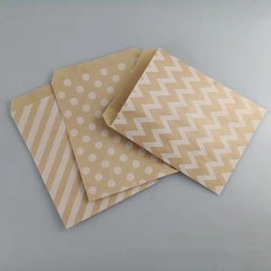 Eco-friendly kraft paper bags with assorted white patterns for gift packaging