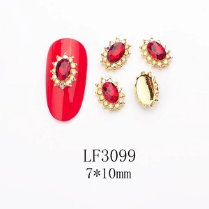 Macro shot of 7x10mm K9 red crystal nail gems with gold alloy and white diamond rhinestones