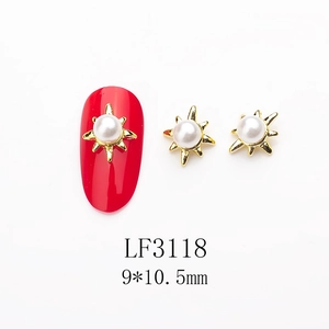 Detail of starburst nail charms with center pearl and gold metal base for manicure