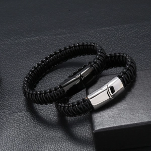 Braided leather bracelets with black and silver magnetic clasps on leather texture