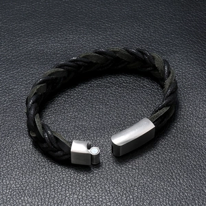 Men's black woven leather bracelet with silver magnetic clasp on leather background