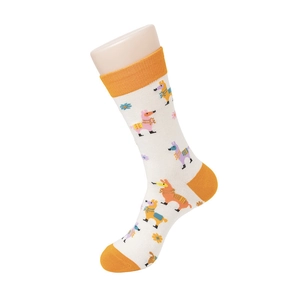 Detail of white mid-calf socks with orange trim and colorful cartoon alpaca patterns