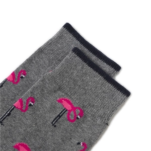 Détail de chaussettes en maille gris foncé avec motifs flamants roses et bords marine