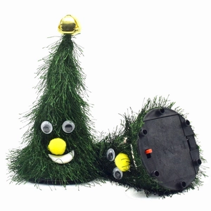 Macro detail of electric dancing Christmas tree plush toy showing base and red power switch