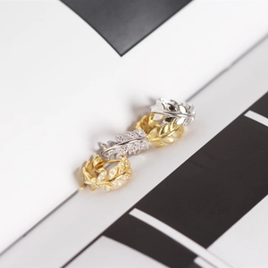Detailed macro view of S925 silver olive leaf hoop earrings with sparkling diamonds