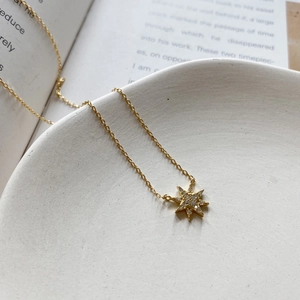 Detailed macro view of 18K gold plated celestial star pendant with white zircon inlays