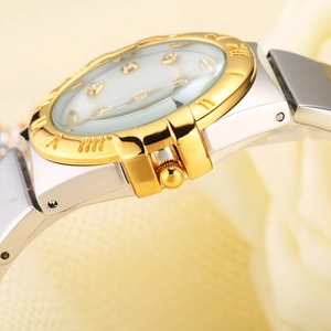 Close-up of the silver stainless steel watch with golden bezel and diamond hour markers