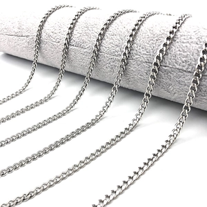Macro view of multiple silver stainless steel Cuban link chains in various widths and sizes