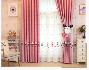 Detail of pink blackout curtains with cartoon prints and a cute reindeer plush tieback