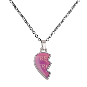 Detailed macro of silver heart pendant with BE FRI engraving and pink-purple gradient finish