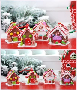 Detailed view of four colorful gingerbread house Christmas ornaments with red hanging loops