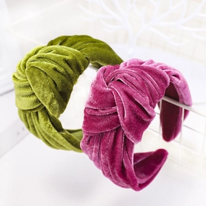 Close-up of velvet knotted headbands in olive green and magenta on white grid