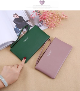 Detail of leather texture on long zipper wallets in green and pink with wrist straps