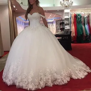 Detail van een off-shoulder trouwjurk met delicaat kant en een gelaagde rok van tule