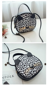 Macro shot of leopard print cat-shaped bag showing faux fur texture and metal heart decor