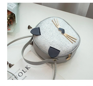 Detail of grey cat-shaped crossbody bag with silver sequins and golden metal cat face details