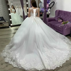 Luxurious white lace ball gown wedding dress with a long train and lace-up corset back