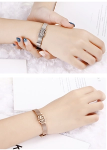 Detail of adjustable mesh bracelet with crown and infinity symbol in silver and rose gold