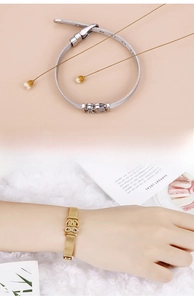 Detail showing mesh band bracelet with heart and infinity charms in gold and silver