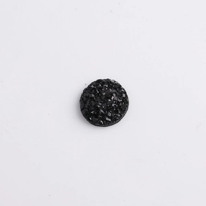Macro detail of black round resin druzy stone with textured sparkling mineral surface