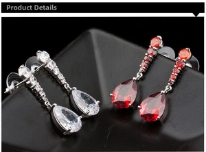 Detail of pear-cut white and red zircon drop earrings with silver metal prong settings