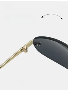 Dettaglio della cerniera in metallo dorato su occhiali da sole alla moda senza montatura