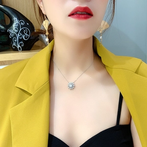 Detail of vintage gold fan earrings with pearls and metallic tassels on a female model