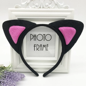 Detail of plush black cat ears headband with pink felt inner lining on a white frame