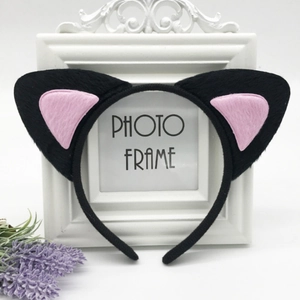 Detail of plush black cat ears headband with pink inner lining on a white frame