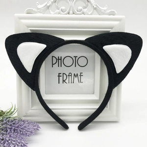 Detail view of black and white plush cat ear headband on vintage photo frame with lavender
