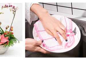 Detail of hand using a white cleaning cloth with pink edges to wipe a floral pattern plate
