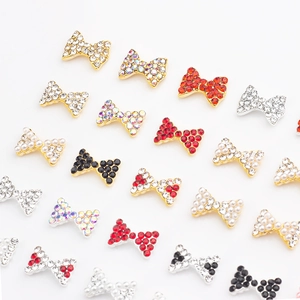 Aperçu de bijoux d'ongles en forme de nœud avec strass rouges et perles nacrées