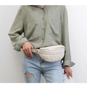 Detail van beige gewatteerde PU-leren heuptas met brede schouderriem op een model