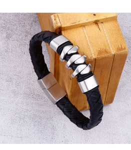 Detailed close-up of men's black braided leather bracelet with silver stainless steel clasp