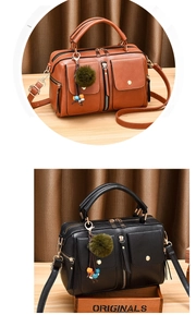 Detail of PU leather Boston bag with dual flap pockets and plush pom-pom keychain