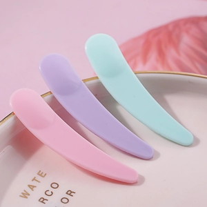 Macaron color crescent facial mask spatulas and cream scoops set on a white plate