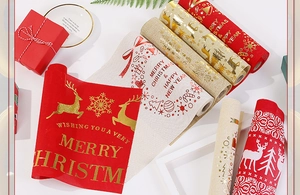 Detail of Christmas table runner rolls with golden reindeer and snowflake prints