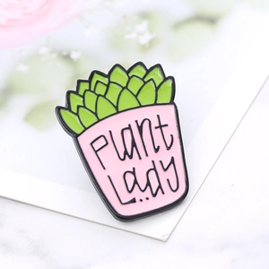 Macro detail of enamel succulent plant brooch with 'PLANT Lady' text and pink pot design