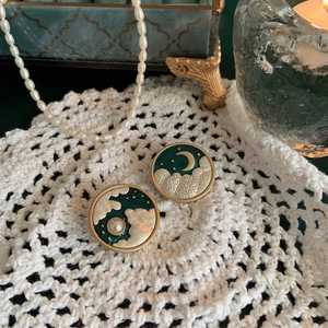 Detailed macro view of vintage dark green enamel brooch with gold moon and star textures