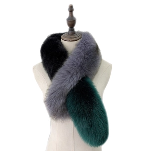 Luxurious fox fur scarf in dark green and grey patchwork worn by a model on white background