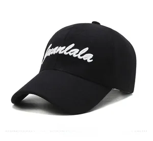 Detail view of premium black baseball cap with white calligraphy embroidery on the front