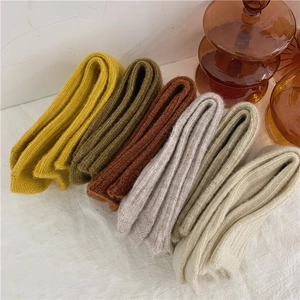 Macro detail of thick wool blend socks in autumn colors like yellow and olive green