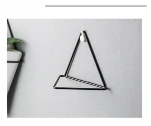 Macro shot of minimalist black metal triangle wall hook with matte finish and geometric design