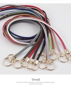 Close-up of colorful braided waist ropes with gold metal buckles on a white background