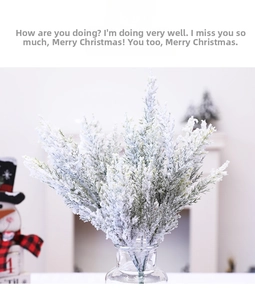 Detail showing frosted PE cedar branches with faux snow in a glass vase for Christmas decor
