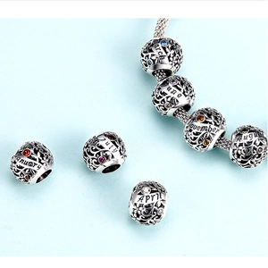 Detailed close-up of S925 sterling silver birthstone charms with hollow patterns
