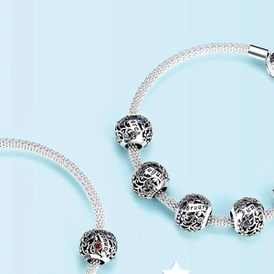 Macro detail of S925 sterling silver charms with colorful birthstones and month engravings