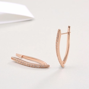 Detail of rose gold V-shaped earrings with micro-paved cubic zirconia and hoop closure